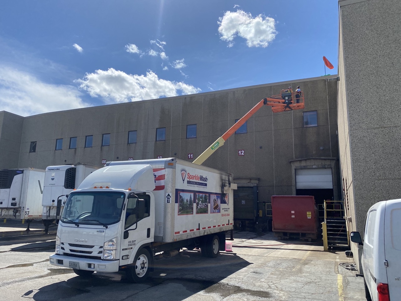 Sparkle Wash service truck parked at commercial building loading dock in Fond du Lac for exterior cleaning and pressure washing services