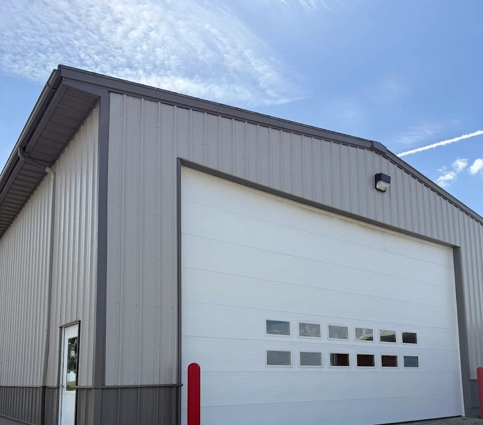 Modern gray metal building with white garage door and small windows in Fond du Lac, Wisconsin after exterior cleaning