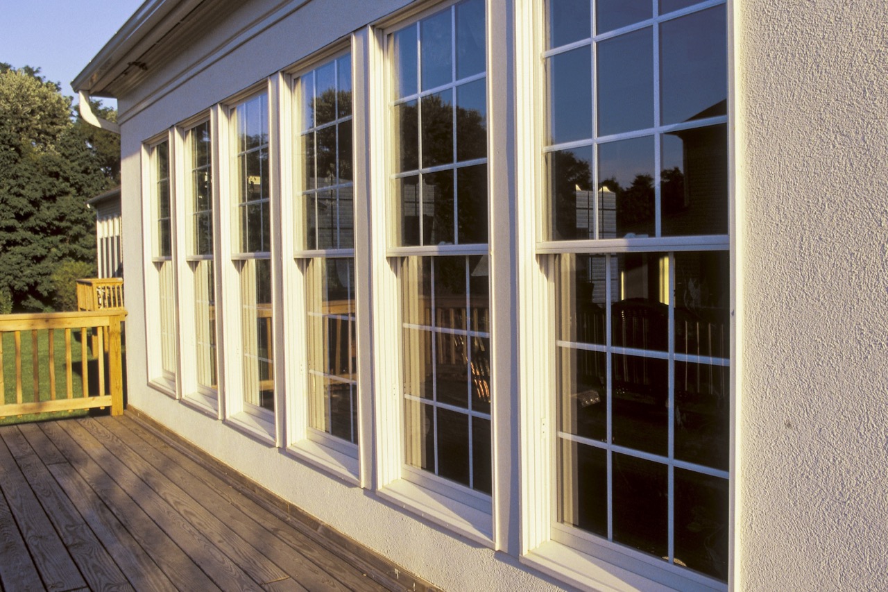 Row of tall multi-pane windows with cream frames on residential building exterior, showcasing professional window cleaning results in Fond du Lac, Wisconsin